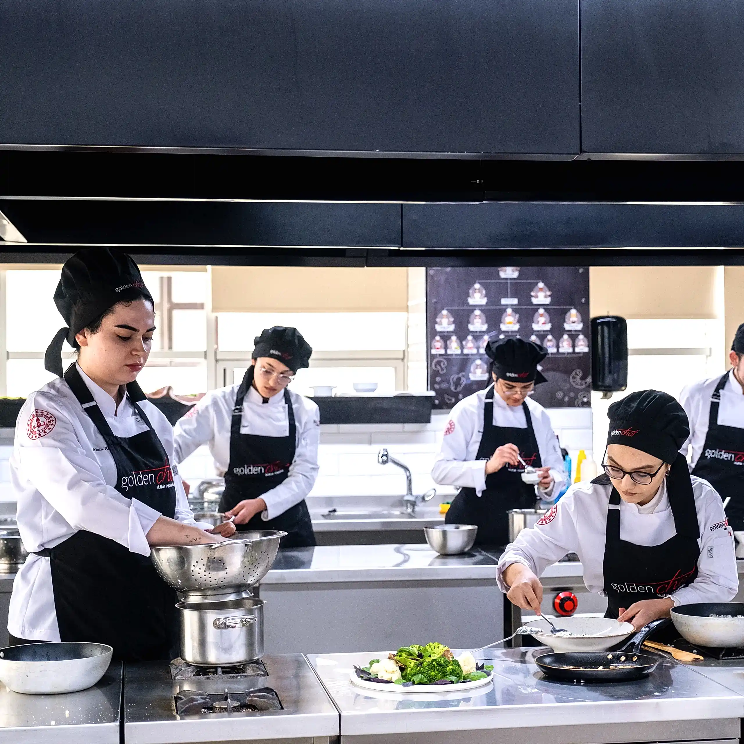 yemek hazırlayan golden chef mutfak akademisi öğrencileri